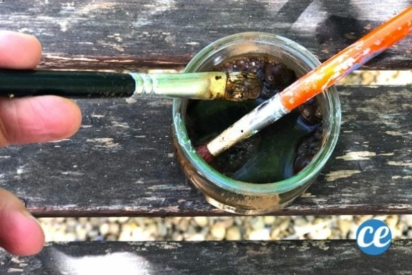 un pot de brou de noix avec des pinceaux