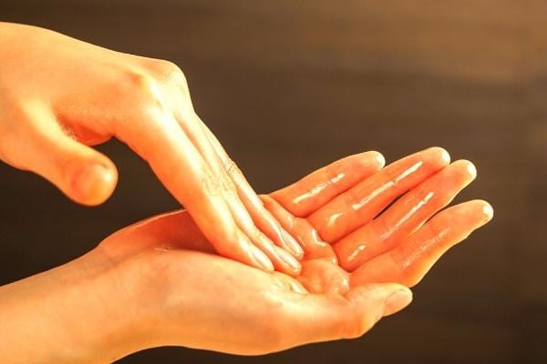 Des mains enduites d'huile d'amande douce