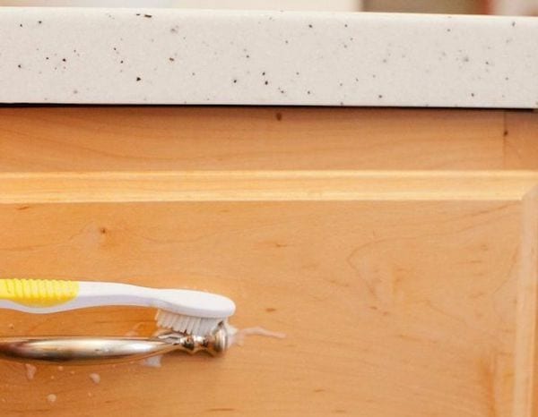 Nettoyage de la quincaillerie des armoires et les poignées de porte avec une brosse à dents 