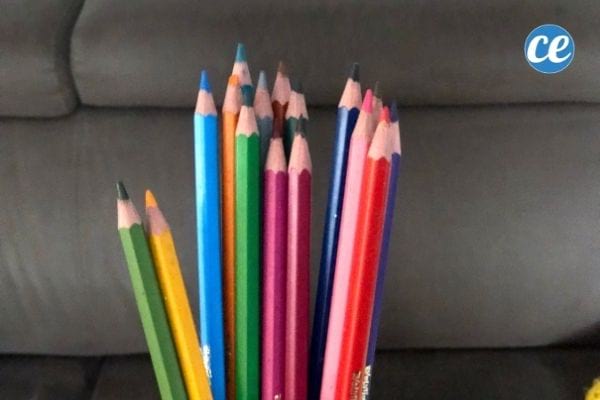 des crayons de couleur devant un canapé marron
