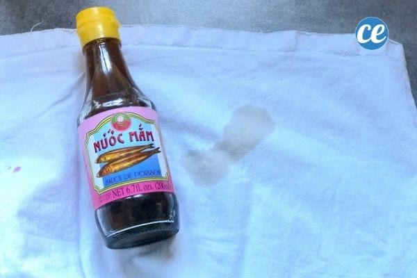 une bouteille de nuoc nam sur un tissu blanc taché
