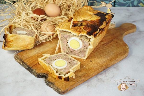 un pâté de pâques avec des oeufs sur une planche en bois