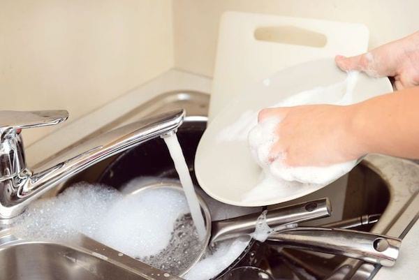 Une personne nettoyant les taches de la vaisselle