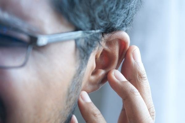 A man touches his left ear
