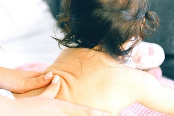 Un massage d'un bébé à l'huile d'amande douce