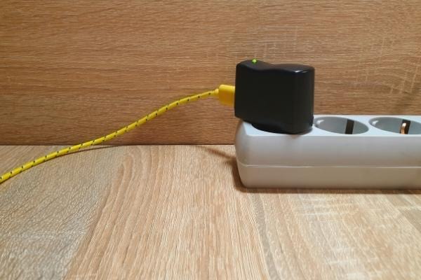 Un chargeur de téléphone laissé branché qui consomme de l'électricité