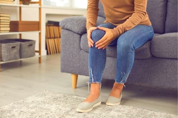 Une femme ayant des rhumatismes se tenant le genou