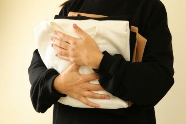 Une femme portant plusieurs sweat-shirts de plusieurs couleurs différentes