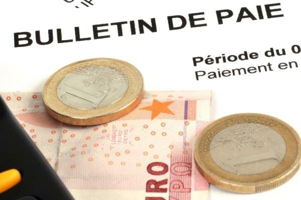De la monnaie posée sur un bulletin de salaire