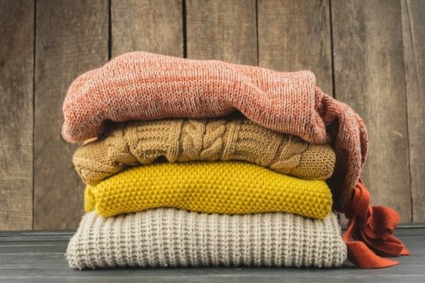 Une pile de pulls en laine de plusieurs couleurs différentes