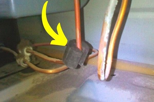 Un silent bloc cassé derrière le frigo qui est cassé et fait du bruit