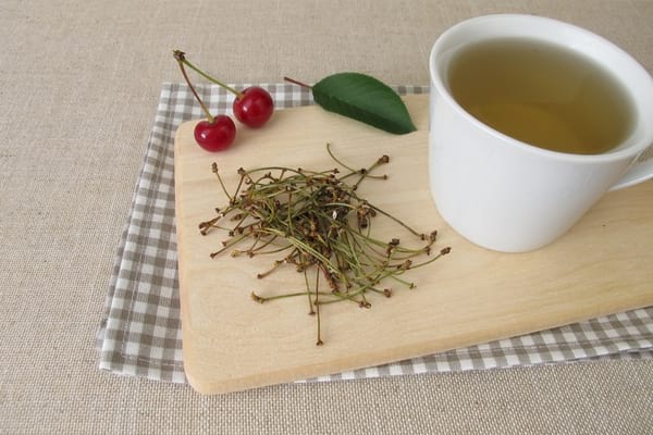queue de cerise et tasse de tisane