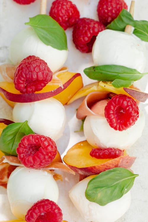 des brochettes de mozzarella et de pêches avec du jambon