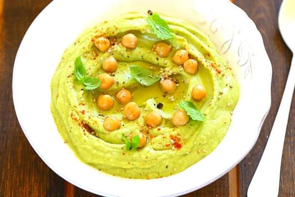 Houmous à l'avocat dans une assiette blanche creuse 