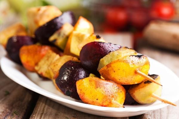 Deux brochettes de fruit dans une assiette 