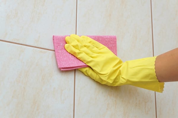 hand that cleans the wall of the tiled toilet in the last step
