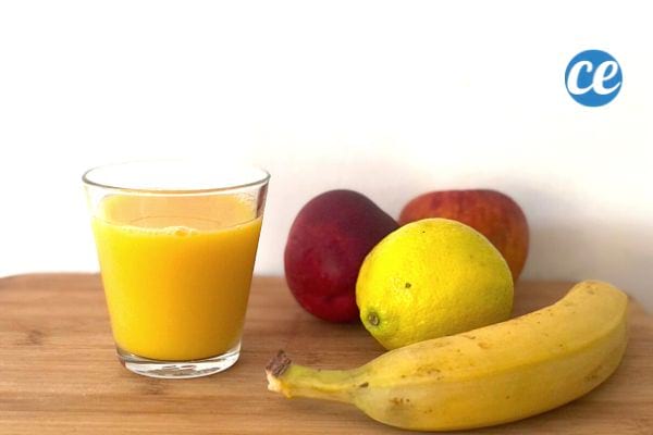 un jus de fruits avec une banane, une pêche, un citron et une pomme pour s'hydrater 