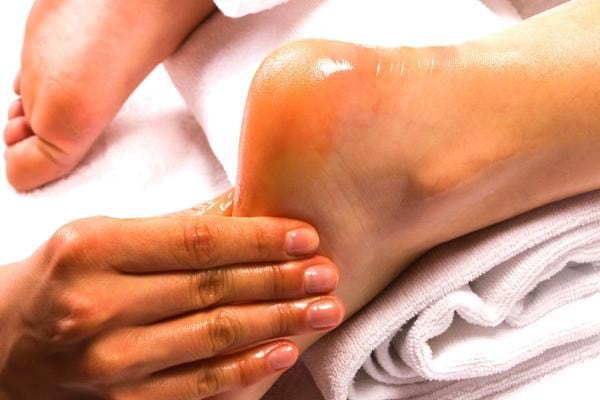 Un massage du pied fait avec l'huile essentielle de lavande pour soulager douleur du talon