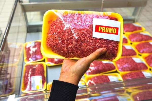 Une personne tenant un paquet de viande en promo 