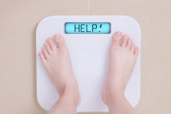 Une balance qui affiche help et une personne qui se père
