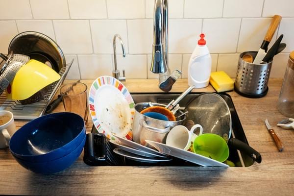 De la vaisselle sale dans un évier qui attire les cafards