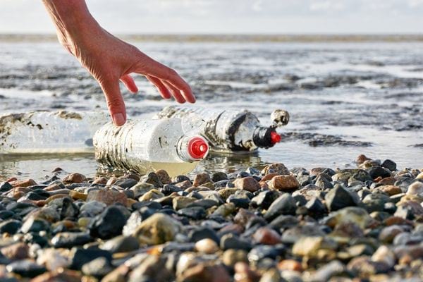 des bouteilles d'eau en plastique jetées sur la plage