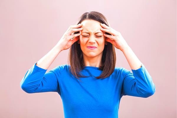 Une femme ayant des maux de tête à cause de l'adoucissant