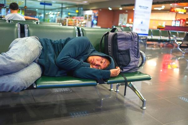 Un homme qui dort dans un aéroport suite à un retard d'avion