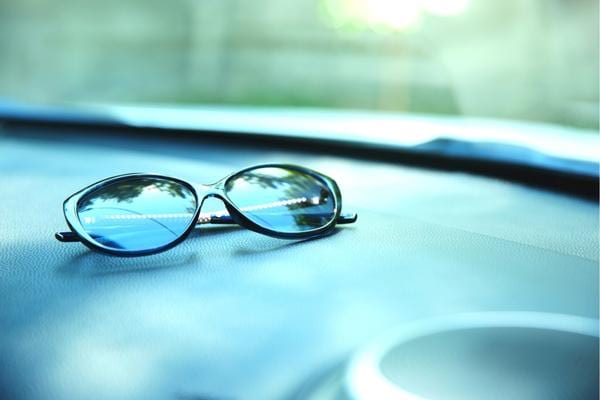 Des lunettes de soleil laissés sur le tableau de bord d'une voiture