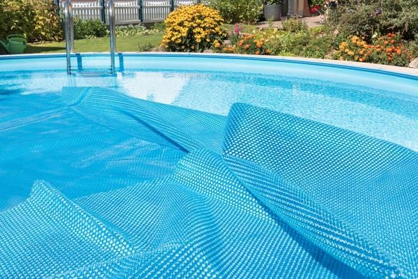 Une bâche solaire mise sur l'eau de la piscine pour éviter l'évaporation de l'eau