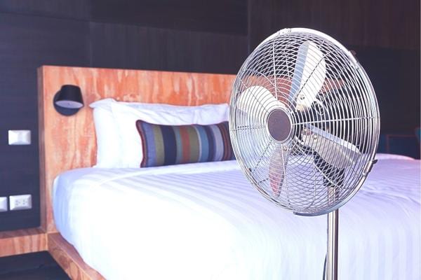 Un ventilateur près d'un lit