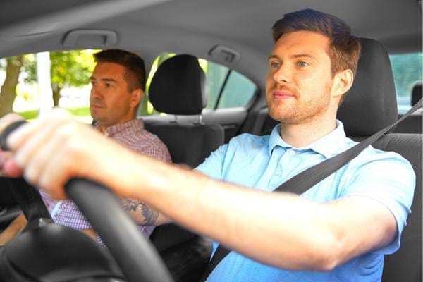 Un homme qui conduit une voiture en douceur pour augmenter la durée de vie des pneus