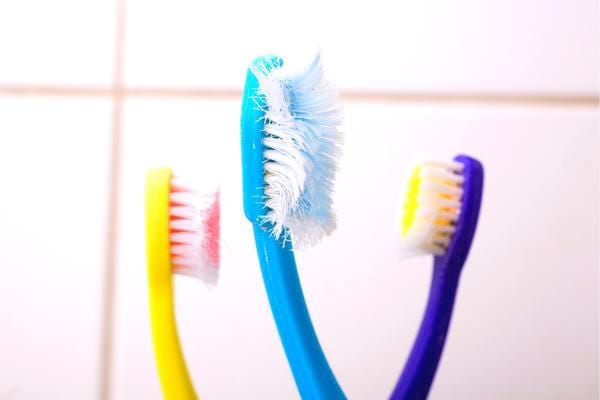 Une brosse à dents usées à cause d'un brossage de dents trop dur qui abime les dents
