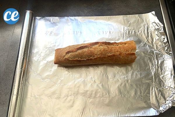 une demie baguette de pain posée sur du papier alu pour être congelée