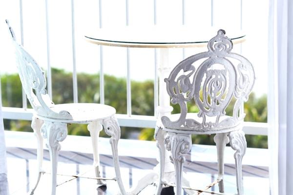 Deux chaises blanche avec une table en extérieur sur une terrasse