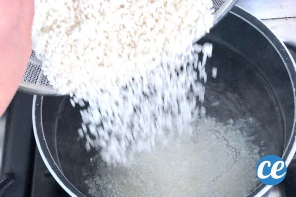 du riz blanc versé dans une casserole avec de l'eau