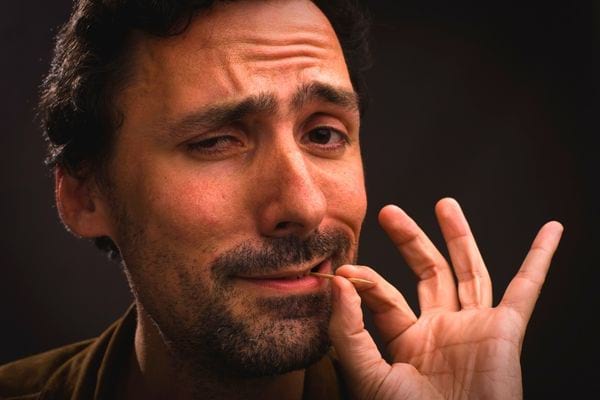Un homme ayant un cure-dent dans la bouche