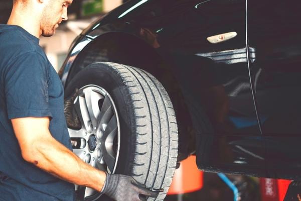 Un mécanicien qui change un pneu hiver pour un pneu été pour augmenter sa durée de vie