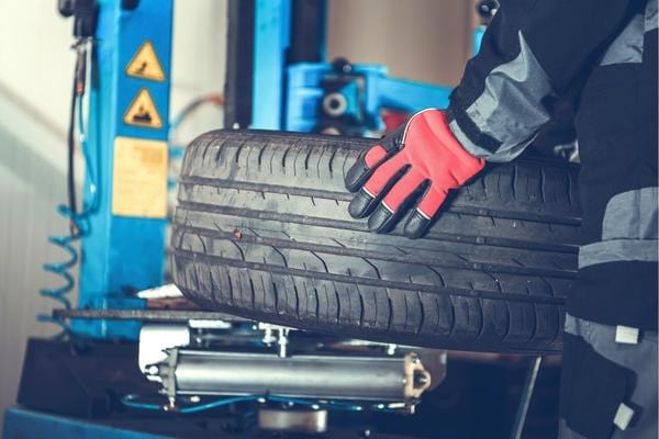 Un mécanicien qui vérifie le parallélisme des pneus pour augmenter leur durée de vie