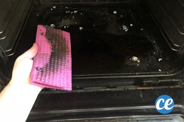 une éponge rose pleine de saleté après avoir nettoyé le four