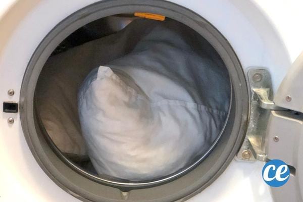 Un oreiller blanc dans une machine à laver 