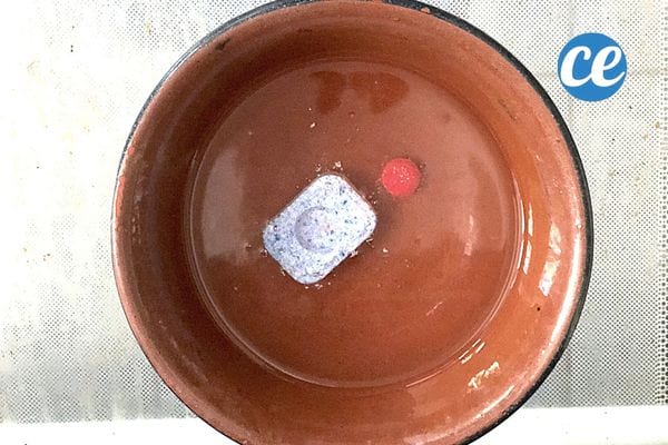 une pastille pour lave-vaisselle dans un bol d'eau