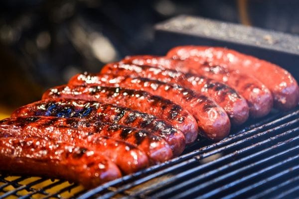 Plusieurs merguez sur le grill d'un barbecue