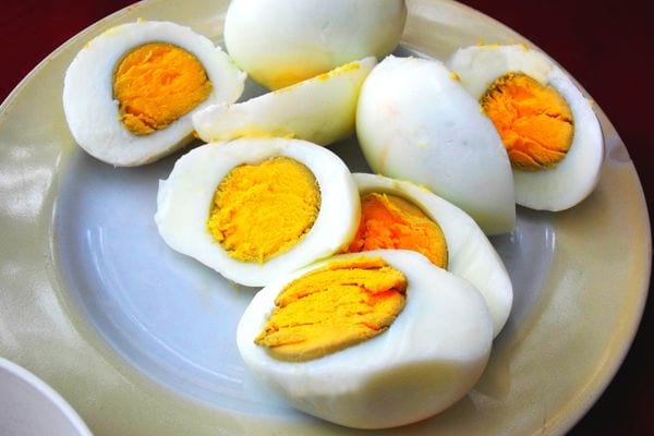 Plusieurs oeufs coupés en deux dans une assiette blanche