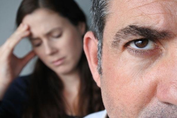 un homme et une femme qui se tient la tête à cause du stress