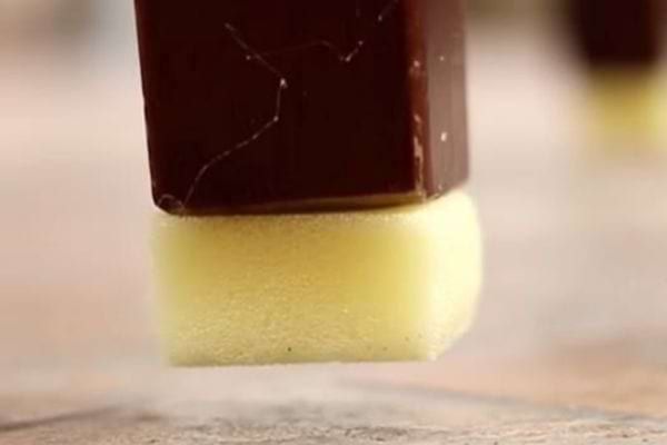 Une petite éponge jaune sous un pied de meuble