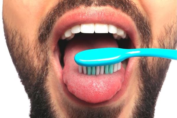 Un homme qui se brosse la langue pour enlever les bactéries 