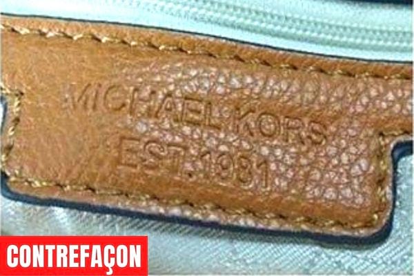Logo Michael Kors sur une partie d'un produit en cuir marron 