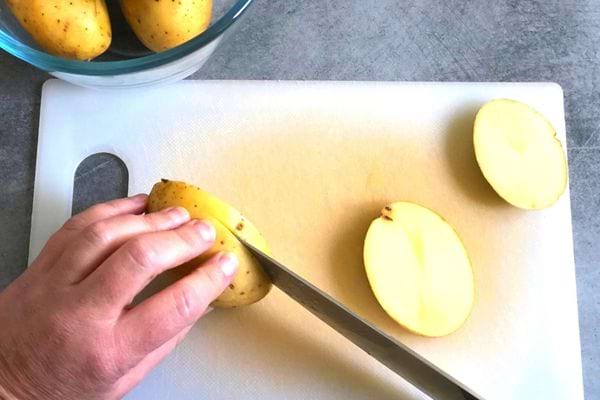 Une personne en train de couper des pommes de terres
