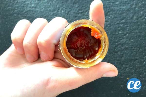 Une personne tenant un baume du tigre rouge